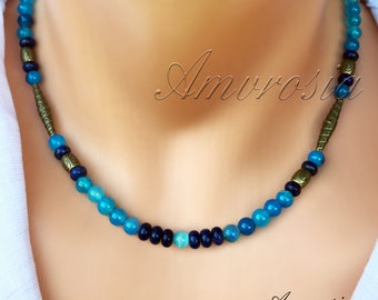 May include: A blue and gold beaded necklace with a gradient of blue beads. The necklace is made with agate and lapis lazuli beads and brass spacers.