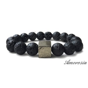 May include: Black lava rock beaded bracelet with a silver cube charm.