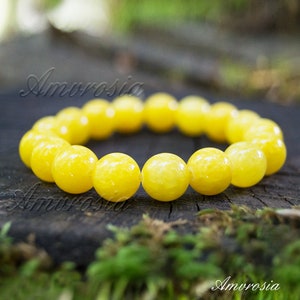 Op de afbeelding: Een gele edelsteen armband met ronde kralen. De armband is gemaakt van natuurlijke stenen en is een mooie accessoire voor elke gelegenheid.