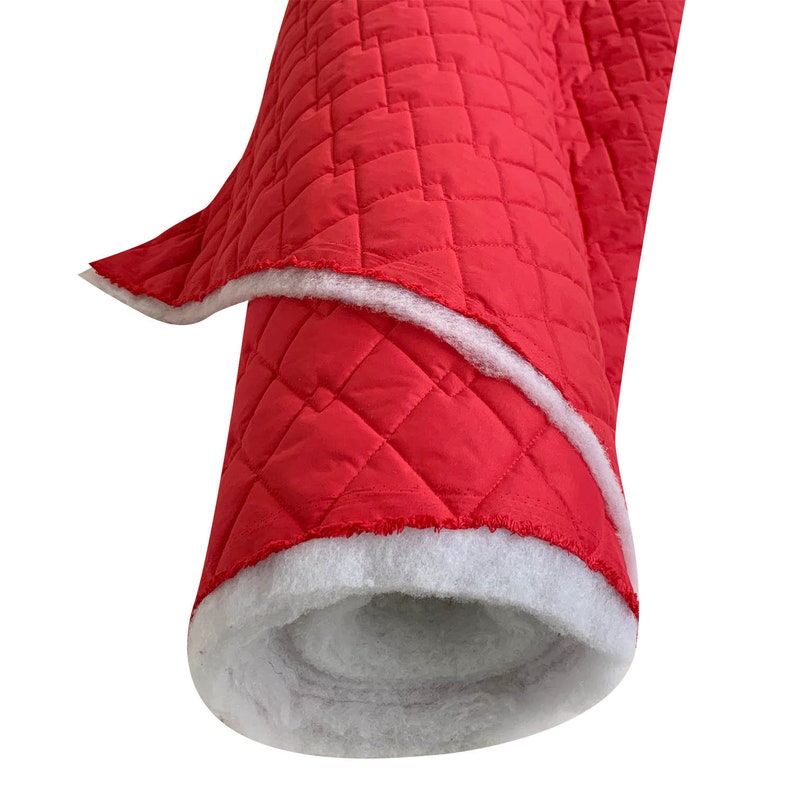 May include: A roll of red quilted fabric with white backing. The fabric is quilted in a diamond pattern.