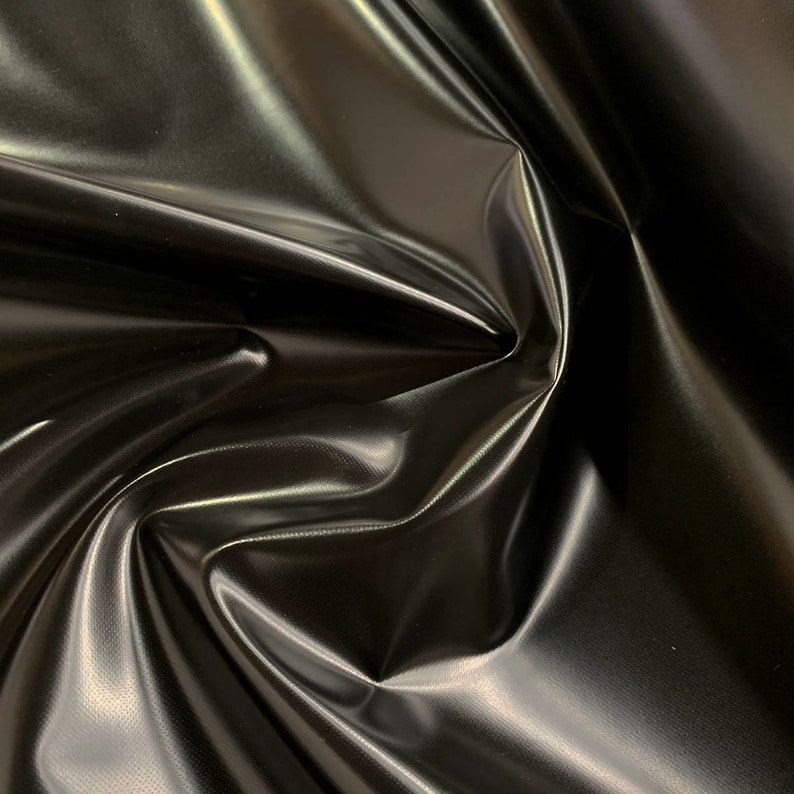 May include: Black shiny fabric with a smooth, glossy finish. The fabric is draped and folded, showcasing its texture and sheen.