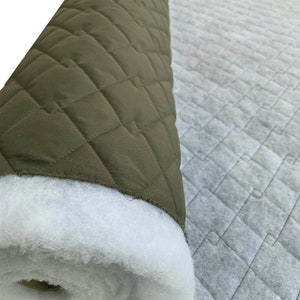 May include: A roll of green quilted fabric with white batting on the inside. The fabric has a diamond pattern.