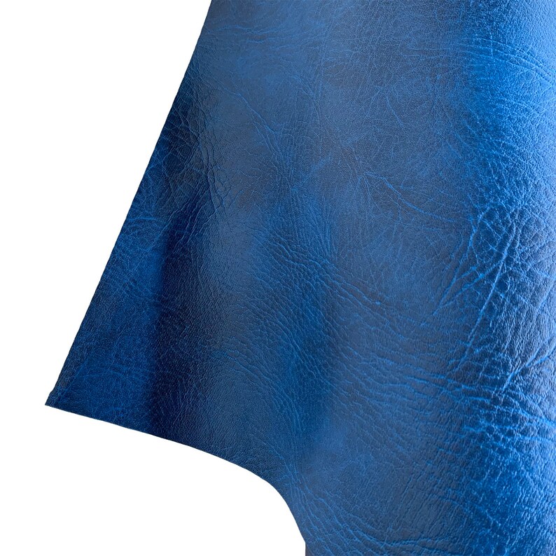 May include: Close-up of a textured blue leather fabric. The leather has a slightly grainy appearance and a deep blue color.