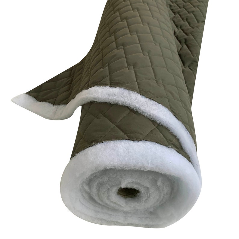 May include: A roll of olive green quilted fabric with a white fleece backing. The fabric is rolled up and the white fleece is visible on the outside of the roll.