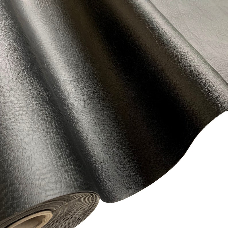 May include: A roll of black faux leather fabric with a textured surface.