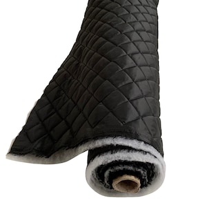 May include: A roll of black quilted fabric with a white backing. The fabric has a diamond pattern.