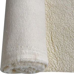 May include: A roll of white fabric with a soft, fluffy texture on one side and a smooth, woven texture on the other side.