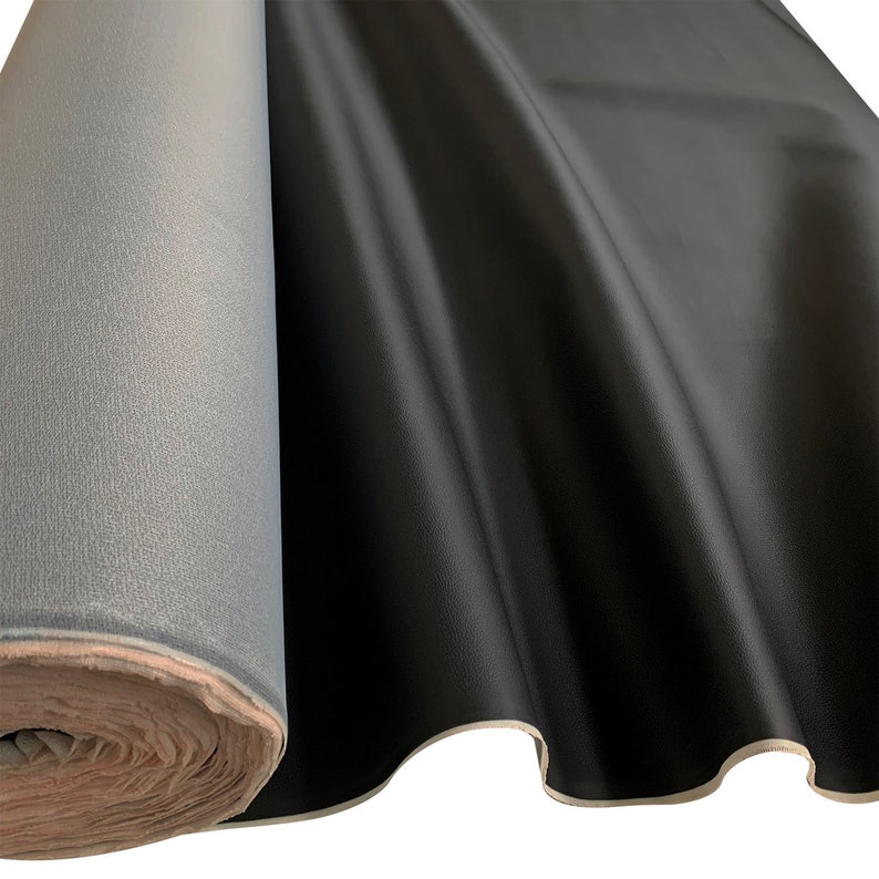 Peut inclure: Un rouleau de tissu en similicuir noir avec une surface lisse et brillante. Le tissu est drap&eacute;, montrant sa texture et sa souplesse. Le dos du tissu est de couleur gris clair.
