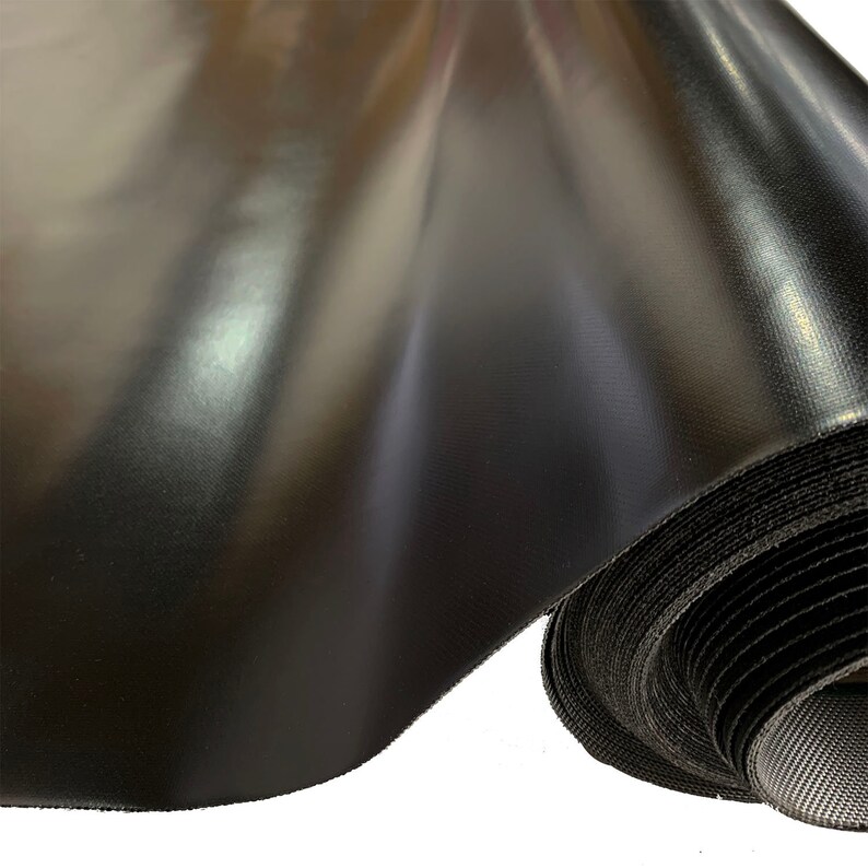 May include: A roll of black fabric with a shiny, satin-like finish. The fabric is rolled up tightly and has a black seam along the edge.