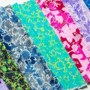 May include: A collection of fabric swatches featuring a repeating sea turtle pattern in various color combinations including purple, black with neon green, dark blue with white, turquoise with yellow, hot pink, and light purple with white.