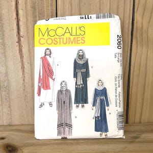 May include: A McCall's Costumes sewing pattern envelope, number 2060, size Ex-Large. The white paper package features illustrations of four different historical or biblical style costumes, including long robes, tunics, and head coverings in white, red, and dark blue colors.
