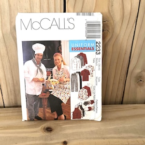 May include: A McCall's sewing pattern for Uniform Essentials, featuring images of chef and server uniforms. The pattern includes various uniform styles, such as chef coats, aprons, and pants. The package is white with the number 2233.