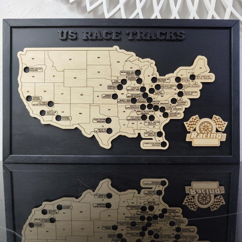 Pu&ograve; includere: Una mappa in legno degli Stati Uniti con cerchi neri che segnano le posizioni di diversi circuiti di corse. La mappa &egrave; montata su una cornice nera con le parole "US RACE TRACKS" in alto. La parte inferiore della cornice ha una bandiera da corsa in legno con la parola "Racing" su di essa.
