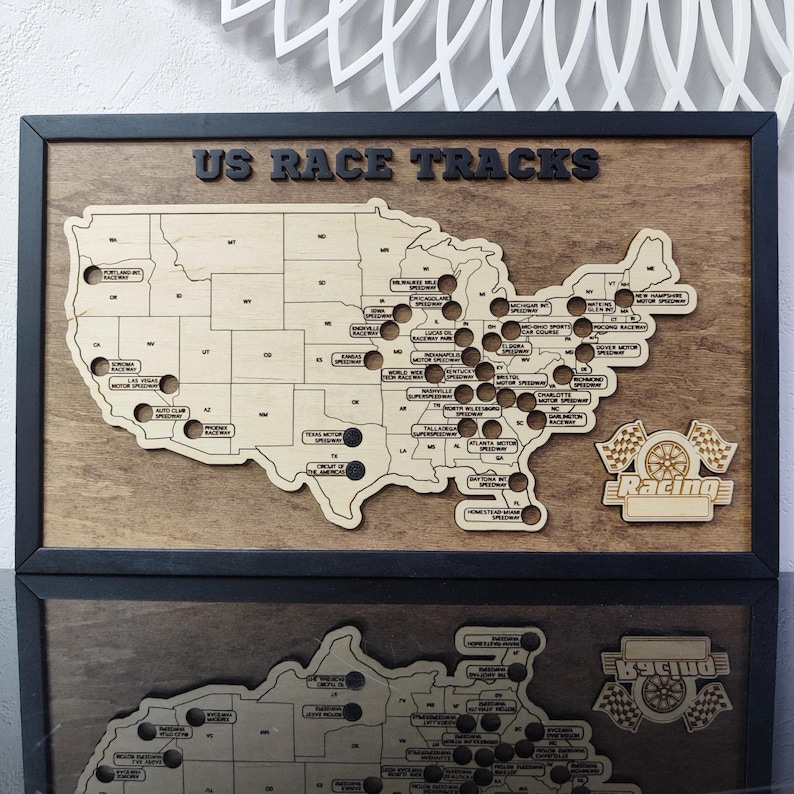 Pu&ograve; includere: Una mappa in legno degli Stati Uniti con punti neri che segnano le posizioni degli autodromi americani. La mappa &egrave; incorniciata in legno nero e ha il testo "US RACE TRACKS" in alto. L'angolo in basso a destra della mappa ha una bandiera da corsa in legno e la parola "Racing".