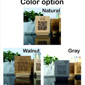Puede incluir: Tres letreros de madera para mesa con diferentes opciones de color: natural, nogal y gris. Cada letrero tiene un c&oacute;digo QR y texto. El letrero natural dice "Enjoy the WIFI". El letrero de nogal dice "Scan for MENU". El letrero gris dice "Scan to CONNECT".