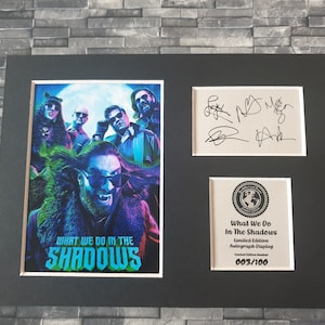 Pu&ograve; includere: Un display autografato in edizione limitata incorniciato del cast dello show televisivo "What We Do in the Shadows". Il display presenta un'immagine colorata del cast e il titolo dello show. Il display &egrave; numerato 003/100.
