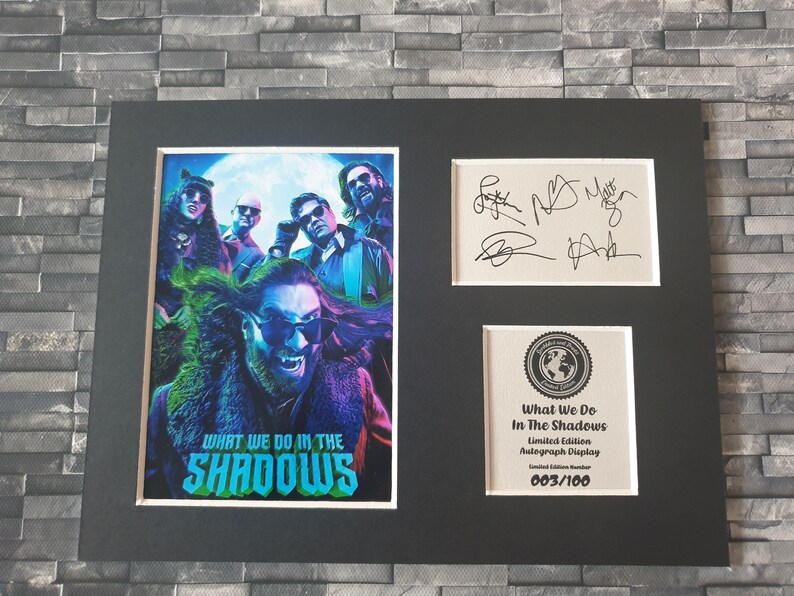 Pu&ograve; includere: Un display autografato in edizione limitata incorniciato del cast dello show televisivo "What We Do in the Shadows". Il display presenta un'immagine colorata del cast e il titolo dello show. Il display &egrave; numerato 003/100.