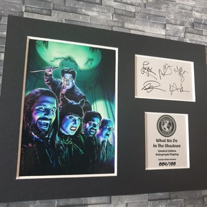 Pu&ograve; includere: Una stampa incorniciata del cast dello show televisivo "What We Do in the Shadows" con le loro autografi. La stampa &egrave; un'illustrazione colorata dei personaggi in un'ambientazione spettrale. La cornice &egrave; nera con un passepartout bianco. La stampa &egrave; numerata 004/100.