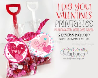 Puede incluir: Dos etiquetas de regalo imprimibles para el Día de San Valentín con un diseño de corazón y el texto "I Dig You!"  Personalizadas con el nombre "Madison".  Las etiquetas están unidas a bolsas de caramelos con corazones rojos y rosas.