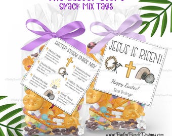 Può includere: Due etichette regalo bianche con un nastro viola legato attorno a sacchetti di mix di snack. L'etichetta a sinistra ha il testo "Easter Story Snack Mix" con un elenco di snack e relativi versetti biblici. L'etichetta a destra ha il testo "Gesù è risorto!" con una croce, una corona di spine e una tomba. Il testo "Buona Pasqua! I Baileys" è in fondo all'etichetta.