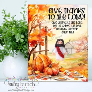 以下が含まれることがあります： 「Give Thanks to the Lord!」のテキストと聖書の詩が書かれた秋をテーマにしたプリント。画像にはカボチャ、紅葉、イエスの姿が描かれています。このプリントは装飾品です。