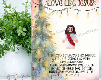 May include: A Christmas-themed print with the text "Love Like Jesus." The image features a watercolor Christmas tree with lights and ornaments, and a small figure of Jesus. The print also includes a Bible verse.