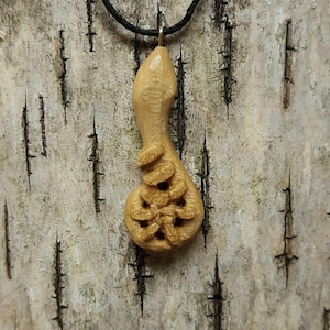 May include: A wooden pendant carved in the shape of a gourd with intricate floral designs. The pendant is attached to a black cord.