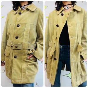 May include: A light olive green corduroy coat with a belted waist, large buttons, and a collared neckline. The coat has two front pockets and a tailored fit, offering a classic outerwear style.