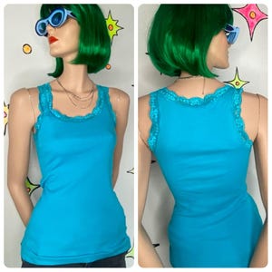 May include: A turquoise tank top with delicate lace trim along the neckline and straps. The fitted top is displayed on a mannequin, showcasing the front and back views. The tank top is a solid color and appears to be made of a soft material.