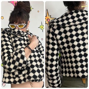 Puede incluir: Una chaqueta a cuadros en blanco y negro con cuello redondo y tres botones negros. La chaqueta tiene mangas largas y un corte corto. El patrón es un diseño de diamantes repetido. La chaqueta se muestra desde el frente y la espalda.