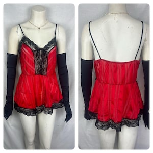 May include: Red satin and black lace lingerie with adjustable straps and a ruffled hem. The lingerie has a fitted bodice and a flowing skirt. The lingerie is paired with black elbow-length gloves.
