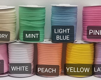 May include: Ten spools of elastic fabric in various colors, including ivory, mint, light blue, pink, light pink, white, peach, yellow, and lavender. Each spool is labeled with the color name.