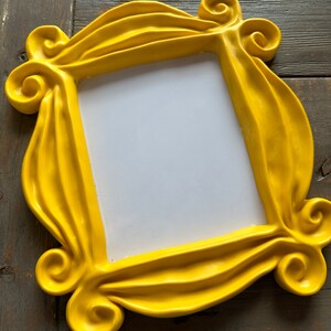 Pu&ograve; includere: Una cornice per foto in plastica gialla con un design ondulato e decorato. La cornice &egrave; vuota e pronta per una foto.