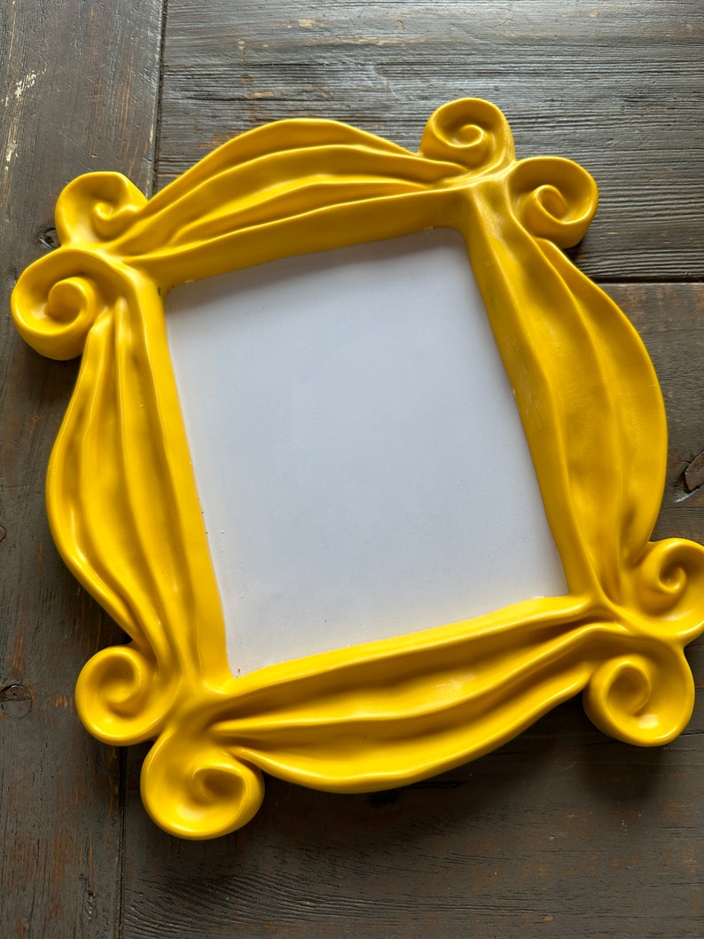 Pu&ograve; includere: Una cornice per foto in plastica gialla con un design ondulato e decorato. La cornice &egrave; vuota e pronta per una foto.