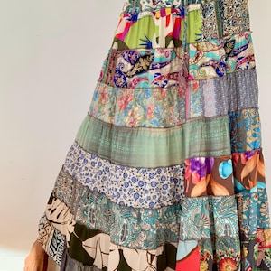 Könnte beinhalten: Ein langer, mehrfarbiger Patchworkrock mit verschiedenen Blumen- und Paisleymustern. Der Rock besteht aus verschiedenen Stoffen und Texturen und erzeugt einen einzigartigen und bohemischen Look.