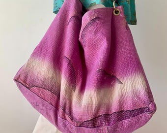 Puede incluir: Un bolso tote grande, rosa, acolchado con un patrón de tie-dye y correas de cuero. El bolso tiene un efecto degradado de rosa claro y blanco en la parte inferior.