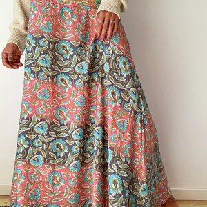 May include: A long, flowing skirt with a pink and blue floral print. The skirt has a gathered waistband and a flowing, A-line silhouette.