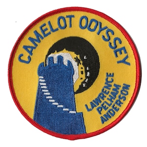 May include: An embroidered patch in yellow and red with the text "Camelot Odyssey" and "Lawrence Pelham Anderson" surrounding a blue and white tower with a black crescent moon behind it.