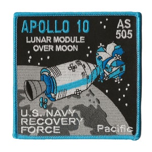 May include: A blue and white embroidered patch with the text "APOLLO 10 LUNAR MODULE OVER MOON AS 505 U.S. NAVY RECOVERY FORCE Pacific" and a graphic of a lunar module over the moon.