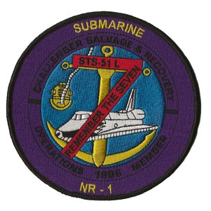 May include: A purple embroidered patch with a gold anchor and a white space shuttle. The text reads "Submarine Salvage & Recovery", "STS-51 L", "Remember the Seven", "Operations 1996 Member", and "NR-1".