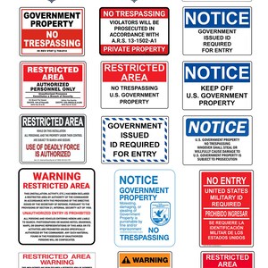 May include: A collection of rectangular signs with bold text and graphics. The signs feature warnings, notices, and restrictions related to U.S. Government property, including "No Trespassing" and "Restricted Area" warnings.