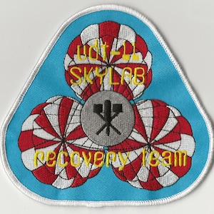 May include: A blue and white embroidered patch with the text "UDT-11 SKYLAB recovery team" and a graphic of three parachutes.