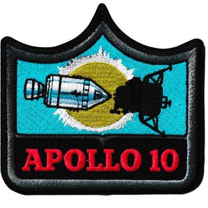 May include: Embroidered patch featuring the Apollo 10 mission. The design includes a rocket, a lunar module, and a yellow sun against a blue background. The text "APOLLO 10" is in red letters on a black banner.