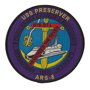 May include: A purple and blue embroidered patch with the text "USS PRESERVER CHALLENGER SALVAGE & RECOVERY OPERATIONS 1986 MEMBER ARS-8" and a white space shuttle with a red diagonal line through it. The text "REMEMBER THE SEVEN" is on the diagonal line.