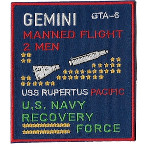 Op de afbeelding: Een blauwe geborduurde patch met de tekst "GEMINI MANNED FLIGHT 2 MEN" en "USS RUPERTUS PACIFIC U.S. NAVY RECOVERY FORCE" in witte, rode en groene letters. De patch heeft ook een witte en grijze illustratie van een ruimtevaartuig en sterren.