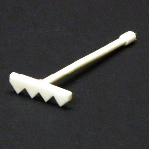 May include: A white plastic rake with a handle and five tines. The rake is small and would be suitable for a miniature garden or dollhouse.