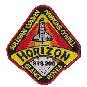 Op de afbeelding: Een zwarte ruitvormige patch met een gele rand en de tekst "HORIZON" in geel. De patch toont een witte spaceshuttle met oranje vlammen en de tekst "SULLIVAN CORVIN HAWKINS O'NEILL GLANCE HINES" rond de rand. De tekst "STS 200" staat in het midden van de patch.