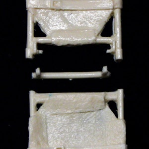 May include: A white plastic stretcher with two sections, each with a fabric-like surface and straps. The stretcher is designed for carrying injured people.