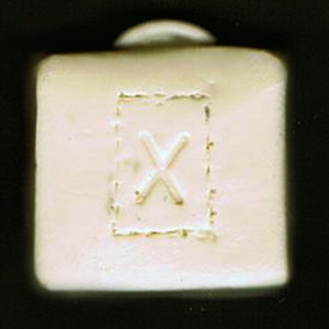 May include: White ceramic tile with a raised, embossed letter 'X' in the centre.