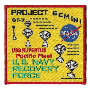 Op de afbeelding: Een gele geborduurde patch met de tekst "PROJECT GEMINI GT-7 USS RUPERTUS Pacific Fleet U.S. NAVY RECOVERY FORCE" en een NASA-logo. De patch toont een ruimtevaartuig dat met parachutes afdaalt.
